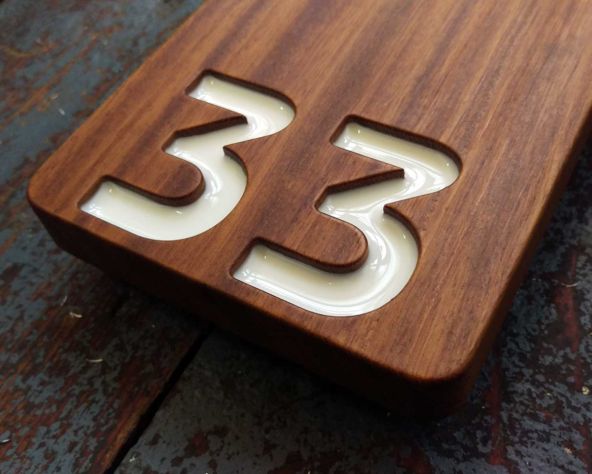 A bespoke house number made from reclaimed mahogany, finished in satin yacht varnish with the numerals in-filled with white epoxy resin.